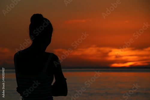Lady during Sunset / Young Lady enjoys the beautiful sunset at the beach of the Indian Ocean, Mauritius, Africa. © sarlay
