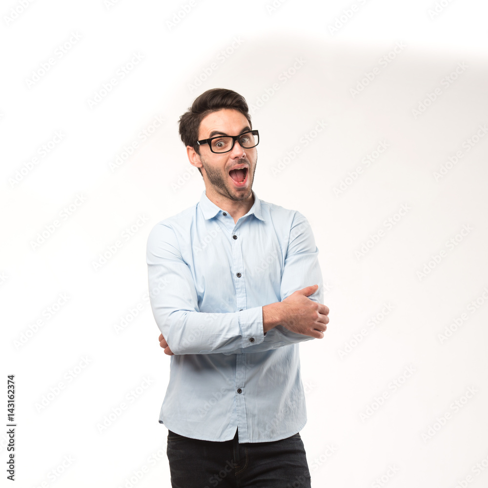 Young happy man showing presentation, pointing on placard over gray background Young happy man showing presentation, pointing on placard over gray background
