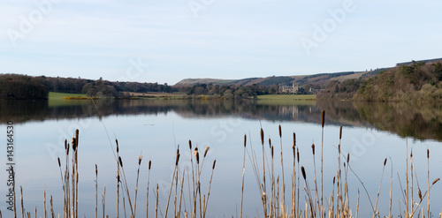 Lochinch Castle viewed across the white loch in Scotland