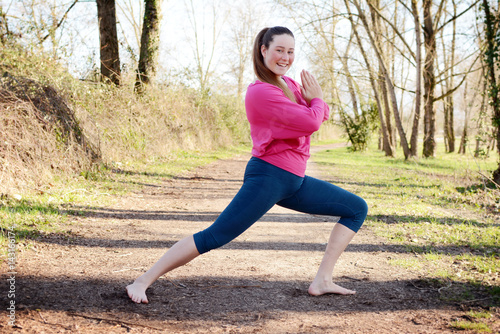 Young beauty woman practicing yoga in the park.