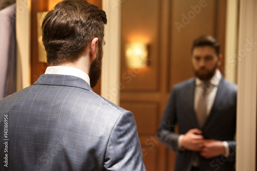 View from back of bearded man looking at the mirror