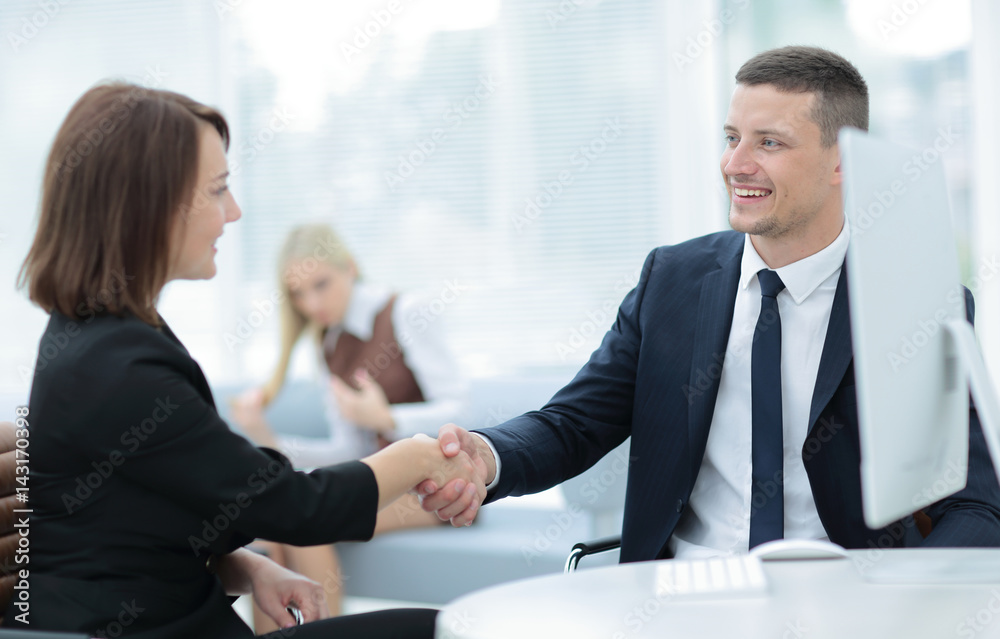 Two business people shaking hands with each other in the office Two business people shaking hands with each other in the office