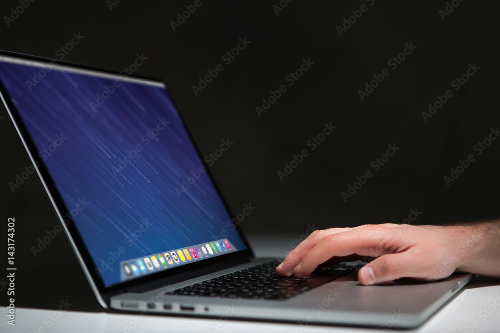 Hand typing on a keyboard of laptop with operating system screen on background Hand typing on a keyboard of laptop with operating system screen on background