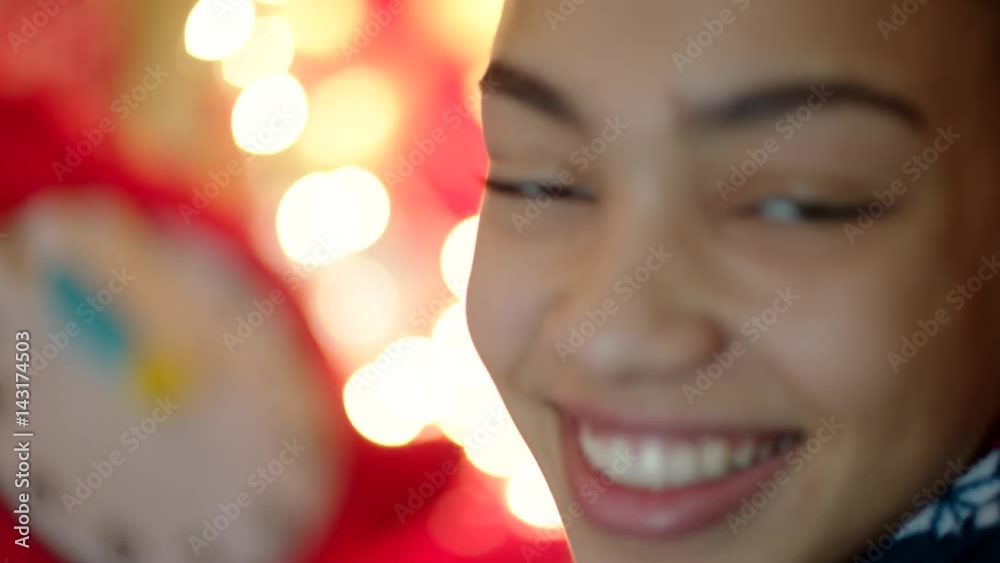 Young woman is looking forward to Christmas night and Santa Claus coming with gifts. She is translating the hands of toy clock to twelve o'clock and smiling Young woman is looking forward to Christmas night and Santa Claus coming with gifts. She is translating the hands of toy clock to twelve o'clock and smiling