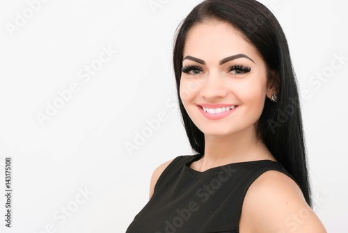 Attractive young woman in a black dress smiling and looking at camera. photo