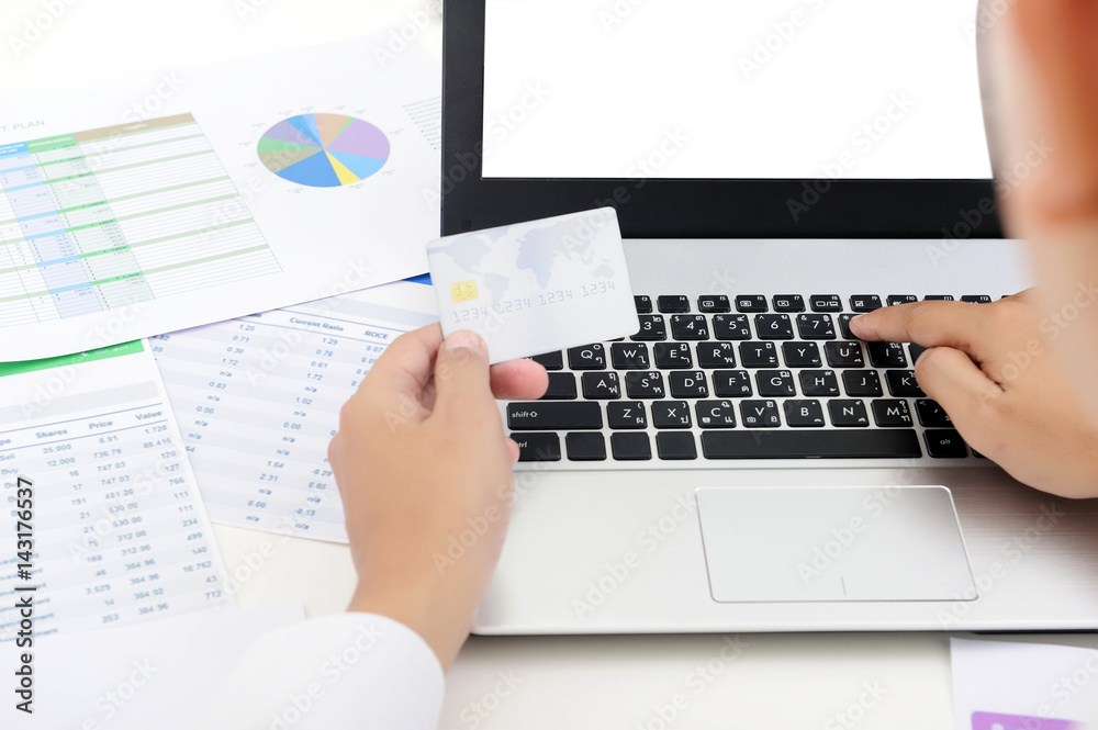 closeup business man hand holding plastic credit card payments and using laptop on office desk closeup business man hand holding plastic credit card payments and using laptop on office desk