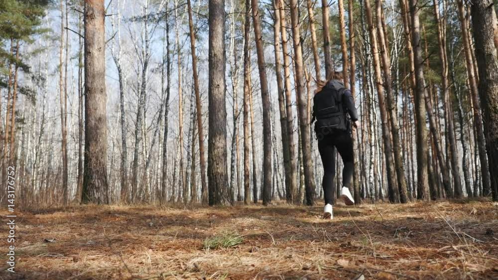 Attractive Fit Woman running in the Forest Path through Trees and Bushes Attractive Fit Woman running in the Forest Path through Trees and Bushes