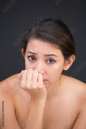 Close up of poor sad depressed, Young woman begging for help and going to cry while standing isolate on black background photo