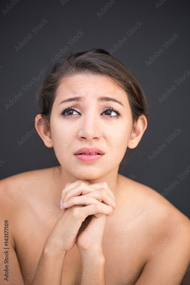 Close up of poor sad depressed, Young woman begging for help and going to cry while standing isolate on black background Close up of poor sad depressed, Young woman begging for help and going to cry while standing isolate on black background
