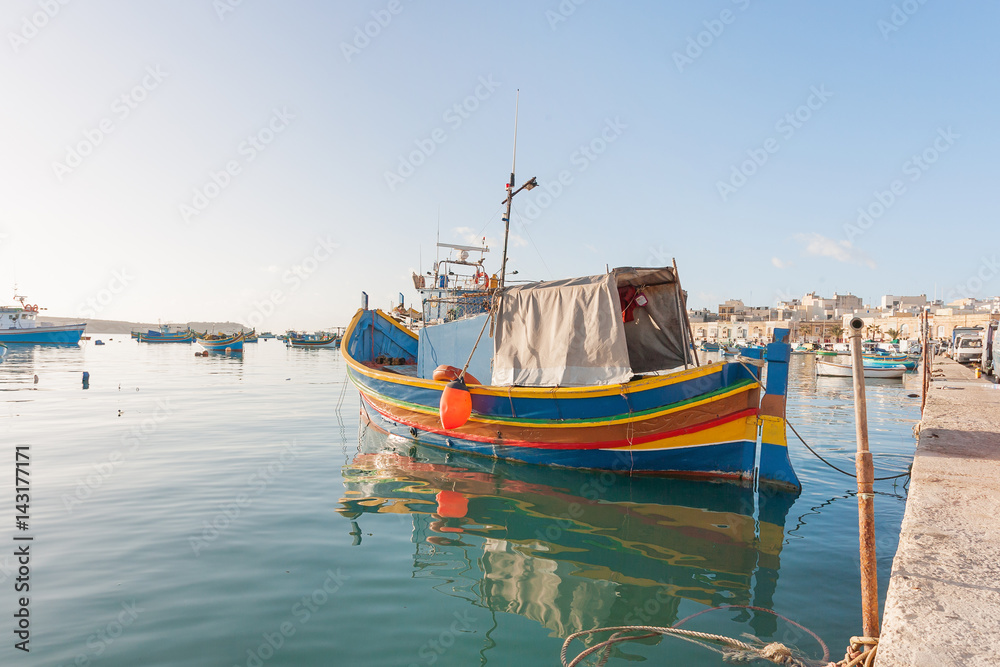 Mediterranean traditional colorful boats luzzu. Fisherman village in the south east of Malta. Early winter morning in Marsaxlokk, Malta.