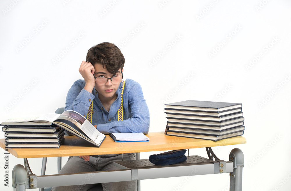 Student sitting at his desk thinking about the exam Student sitting at his desk thinking about the exam