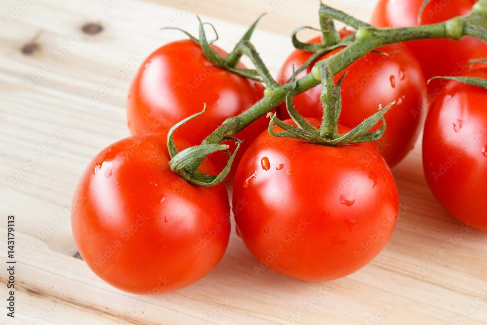Bunch of fresh organic tomatoes on a wooden background Bunch of fresh organic tomatoes on a wooden background