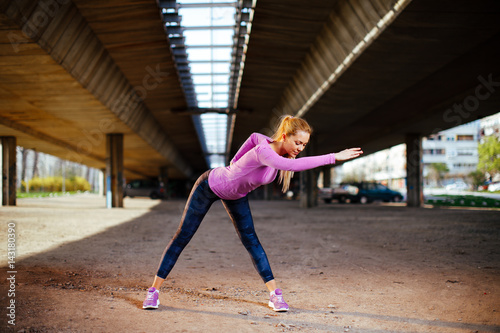 Young woman stretching arms and backs under the bridge © djile