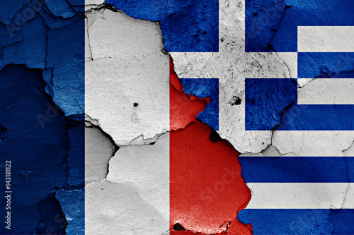 flags of France and Greece painted on cracked wall