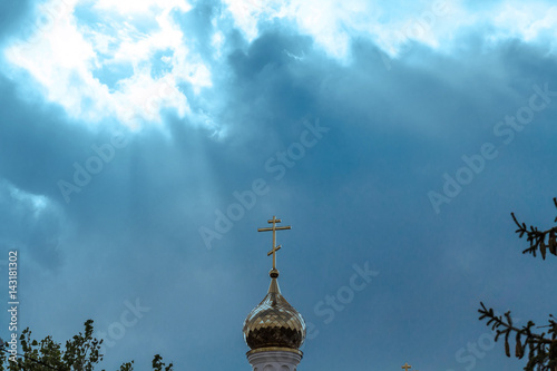 Orthodox cross at church rooftop against blue sky photo