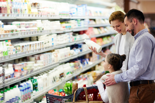 Fototapeta Modern family choosing dairy products in supermarket