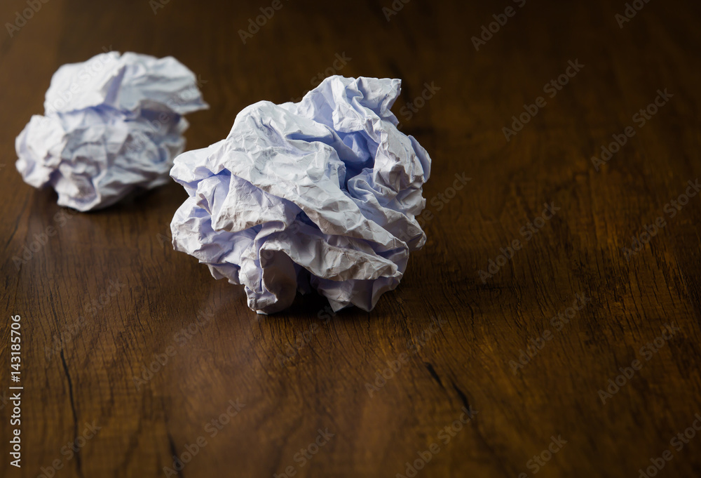 White crumpled paper ball on desk background