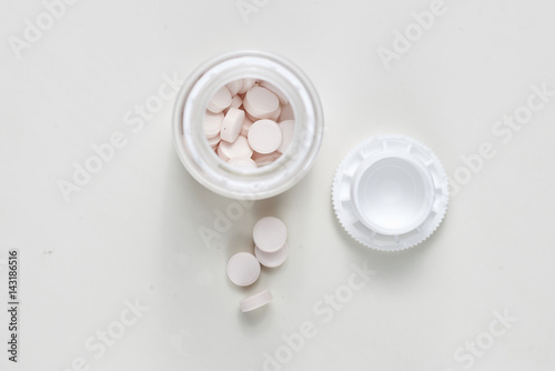 open glass container with medical pills