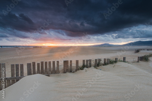 dramatic sunset and storm clouds over beach in Tarifa, Spain