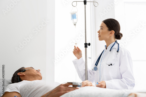 Calm physician making drip flask for patient