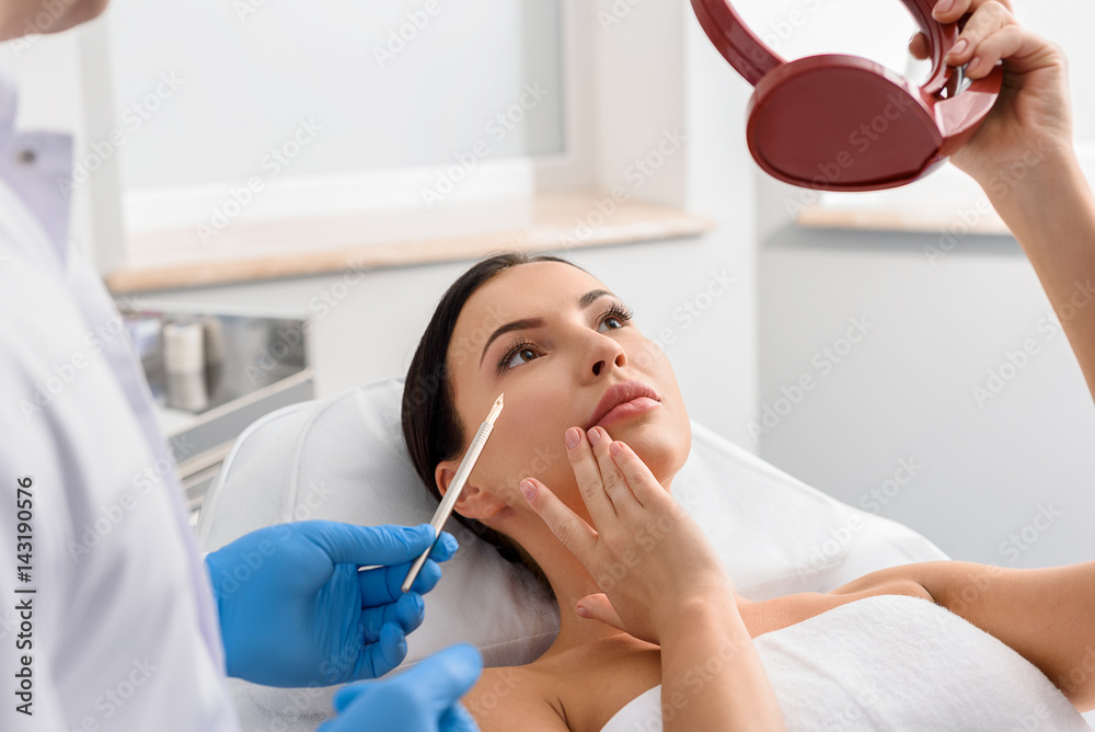 Physician demonstrating problem-prone skin of woman Physician demonstrating problem-prone skin of woman