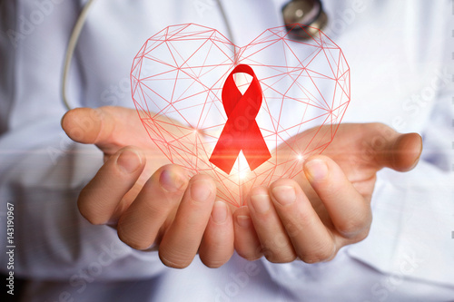 Фотография Ribbon for the fight against AIDS in the hands.