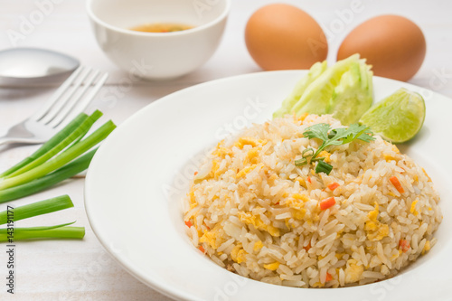 Fried rice with spicy sauce on white wooden background