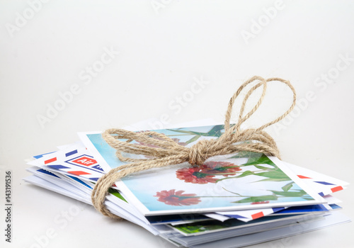 Postcards and envelopes are tied together with rope.