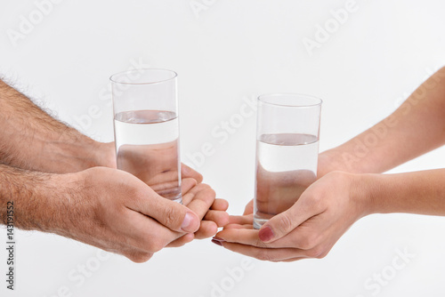 People keeping glasses with water