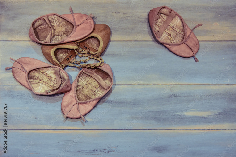 Small used shoes for dance, isolated on wooden background. Small used shoes for dance, isolated on wooden background.