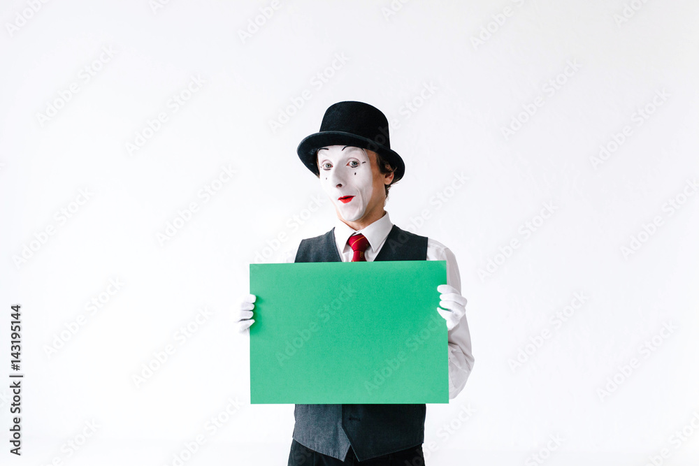 Confident mime holds green paper in his arms Confident mime holds green paper in his arms