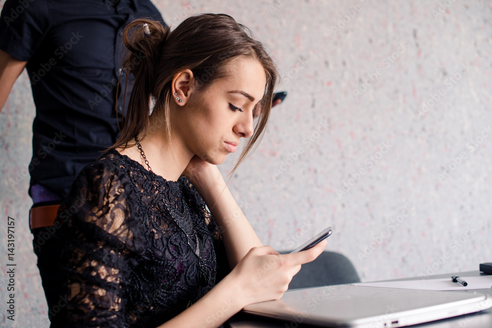 Girl checks her phone at office Girl checks her phone at office