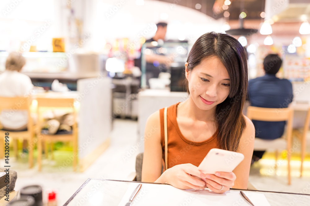 Woman using mobile phone in restaurant Woman using mobile phone in restaurant