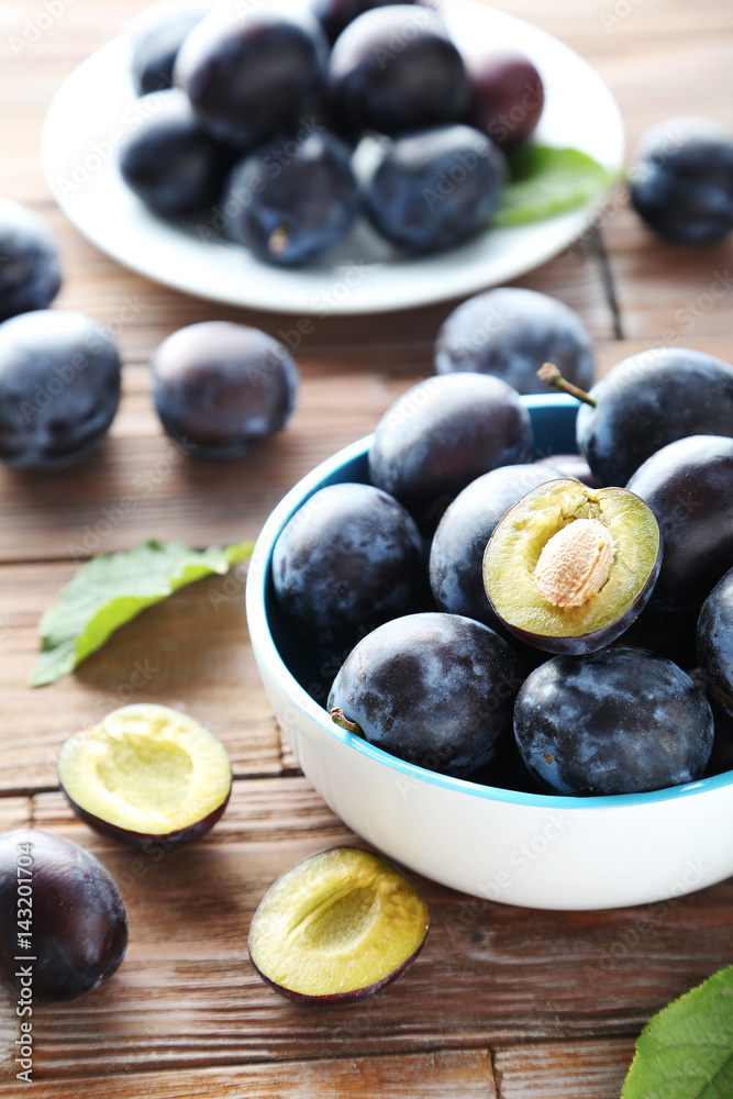 Tasty and ripe plums on brown wooden table Tasty and ripe plums on brown wooden table