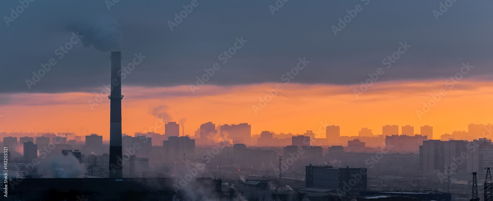 Panoramic view of a foggy industrial city smoke fog and sunset