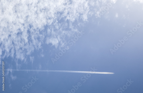 Big white airplane with four engines over blue cloudy sky