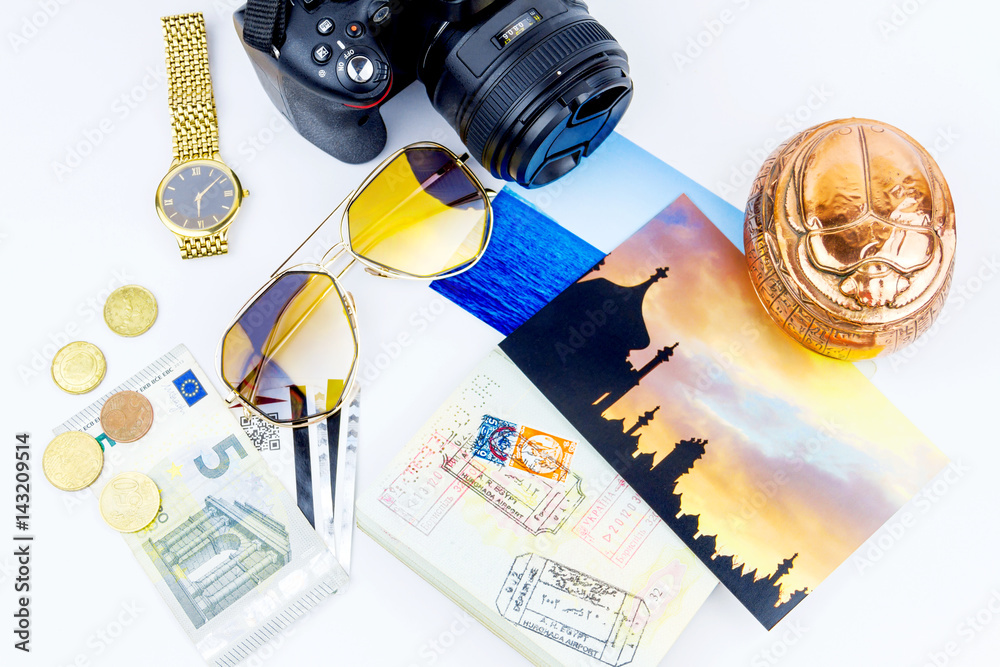 Fototapeta premium Top view. Objects of a traveler isolated on white background: envelope, souvenir, camera, cash, sunglasses, watch, photos of Turkey and the sea and passport with visas