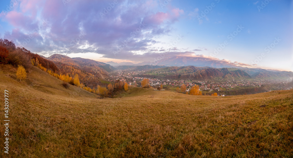 Beautiful sunset panorama with forests, mountains and village