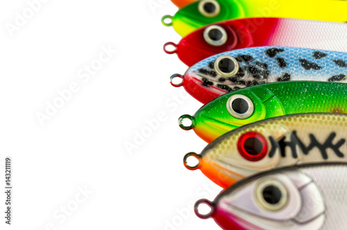 Fishing lures standing in a row. Multicolored fishing lures isolated on white background.