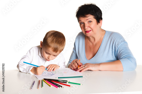 Grandmother with grandson learn and draw at table on a white background