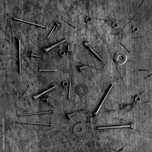 Set of golden screws, bolts, nails, washers, nuts on wooden background
