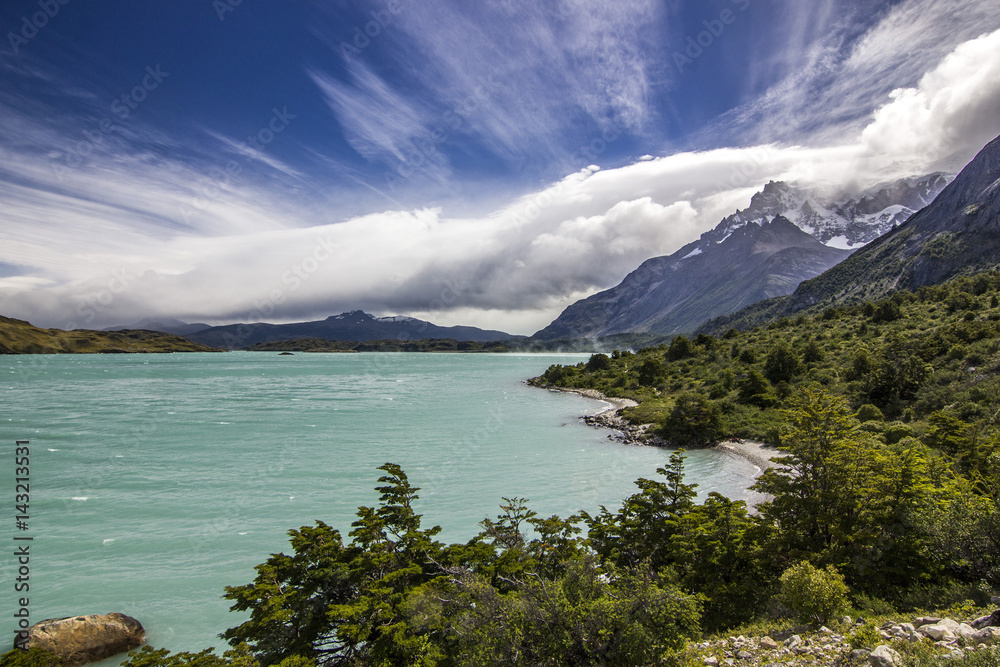 shore of blue lake and clouded sky in patagonia at daylight