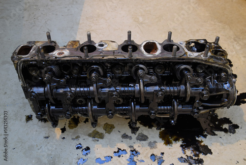 The head of the block of cylinders. The head of the block of cylinders removed from the engine for repair. Parts in engine oil. Car engine repair in the service