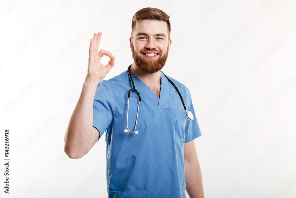 Happy friendly male doctor with stethoscope showing ok gesture Happy friendly male doctor with stethoscope showing ok gesture