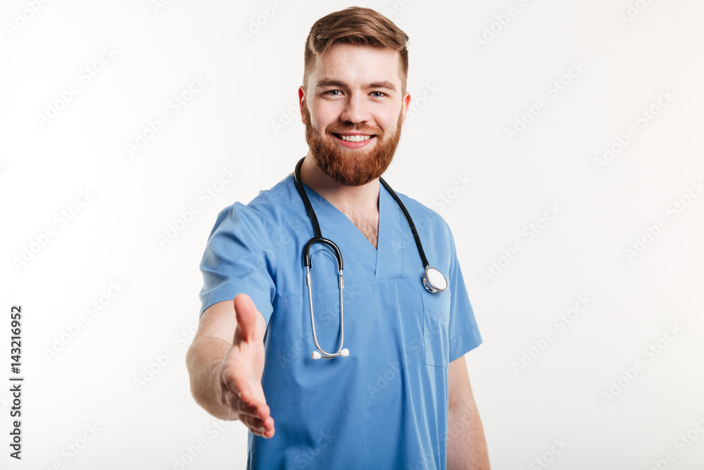 Portrait of a friendly smiling doctor stretching hand for handshake Portrait of a friendly smiling doctor stretching hand for handshake