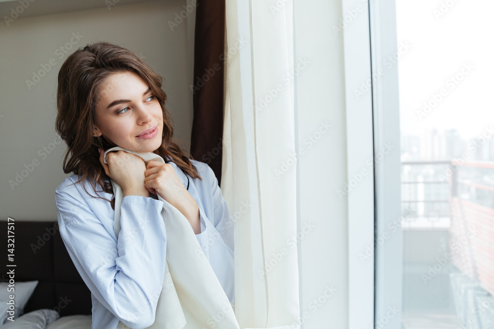 Portrait of a happy woman opening window curtains Portrait of a happy woman opening window curtains