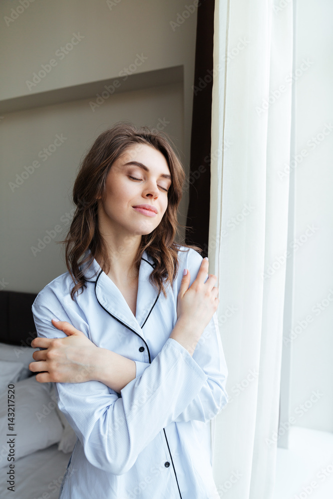 Young woman in pajamas facing the sunrise in the morning Young woman in pajamas facing the sunrise in the morning