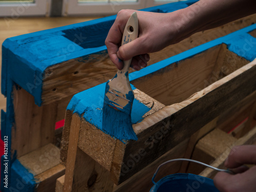 Woman painting wooden pallet