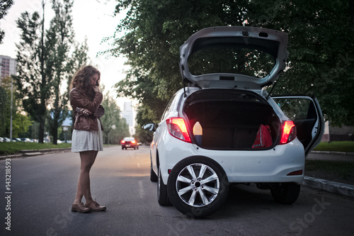 Young girl has problems with the car, wheel replacement