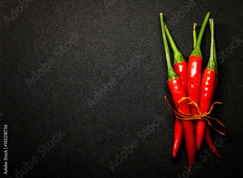 Tablou pe pânză Red chili peppers on black background, Fresh hot chili peppers.